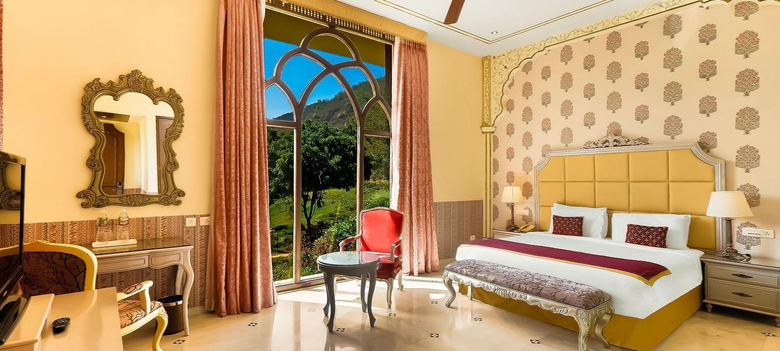 Elegant double bedroom at Rajasthali Resort Jaipur with plush interiors, arched windows, and royal decor touches.