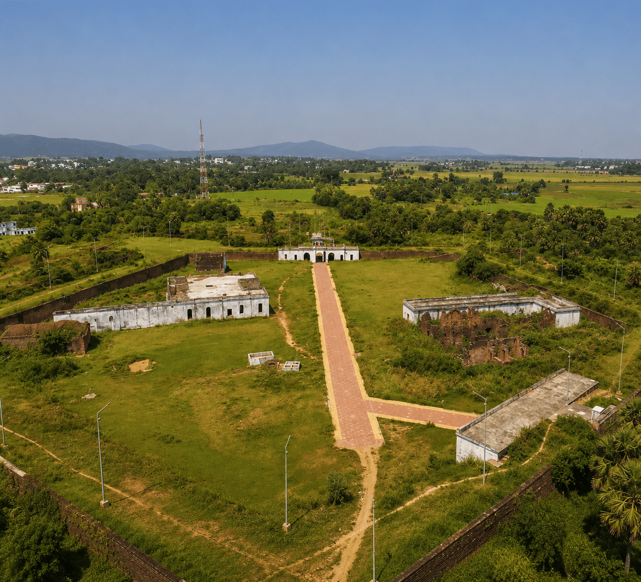 Aerial of Pota Gada Fort with brick ramparts, whitewashed buildings, a ruined block and a paved central path, near MAYFAIR Palm Beach Resort, Gopalpur-on-Sea.