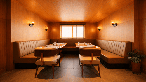 A dining area featuring built-in booth seating along the walls and tables in the centre | Pride Premier Darjeeling