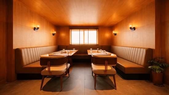 A dining area featuring built-in booth seating along the walls and tables in the centre | Pride Premier Darjeeling