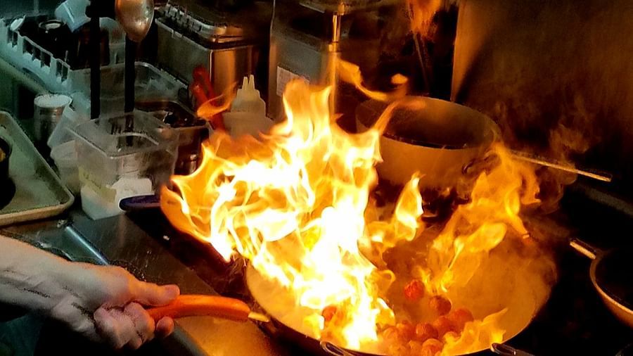 A fiery cooking scene with flames igniting the kitchen - Brewery Gulch Inn & Spa