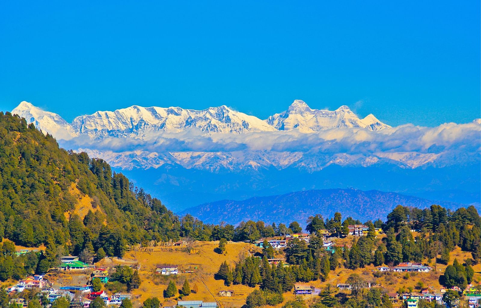 A panoramic view of a mountain landscape with clouds and colorful flags, showcasing a beautiful valley.