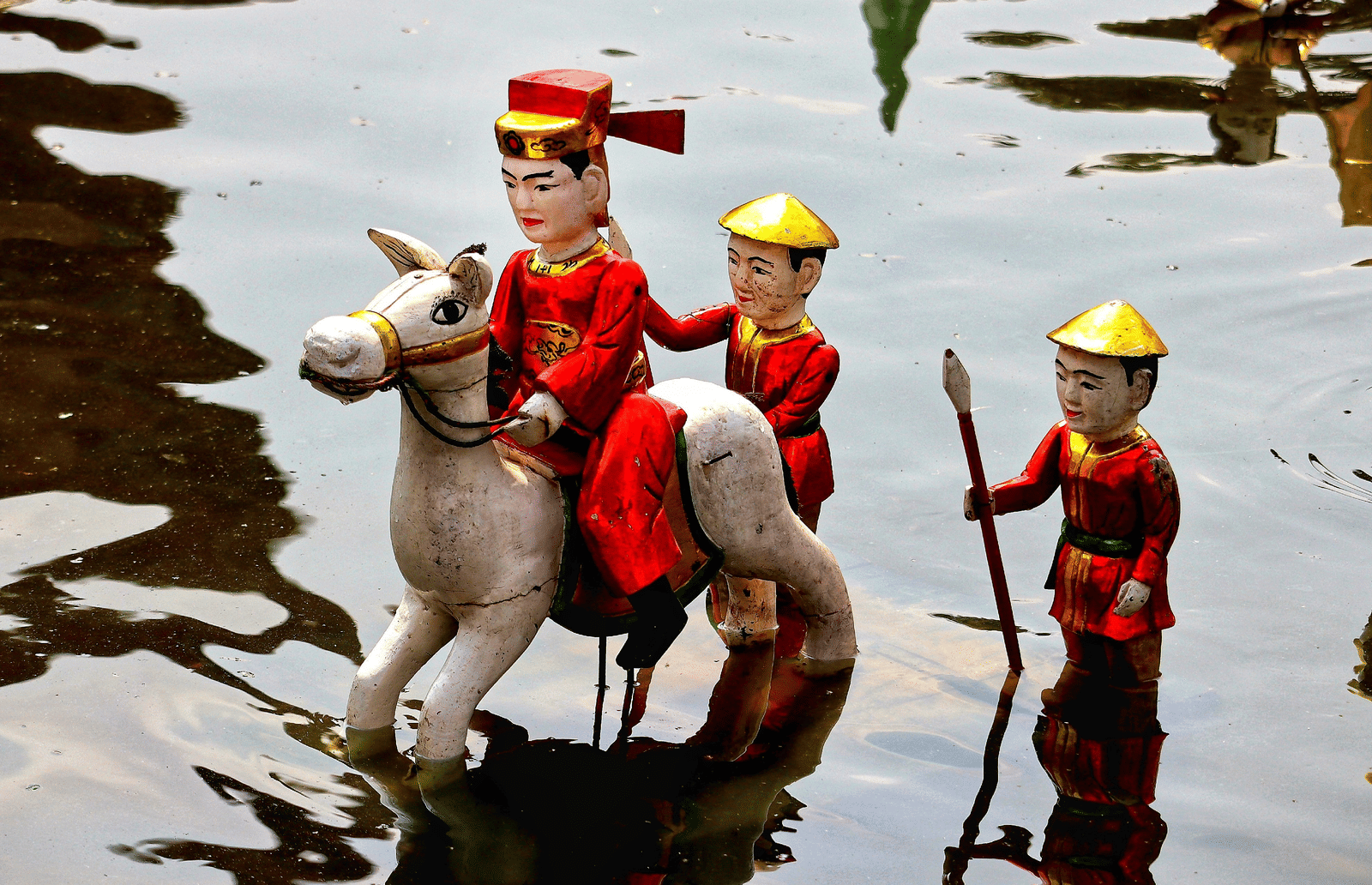 A close up of puppets dressed in military outfit and placed in a waterbody.