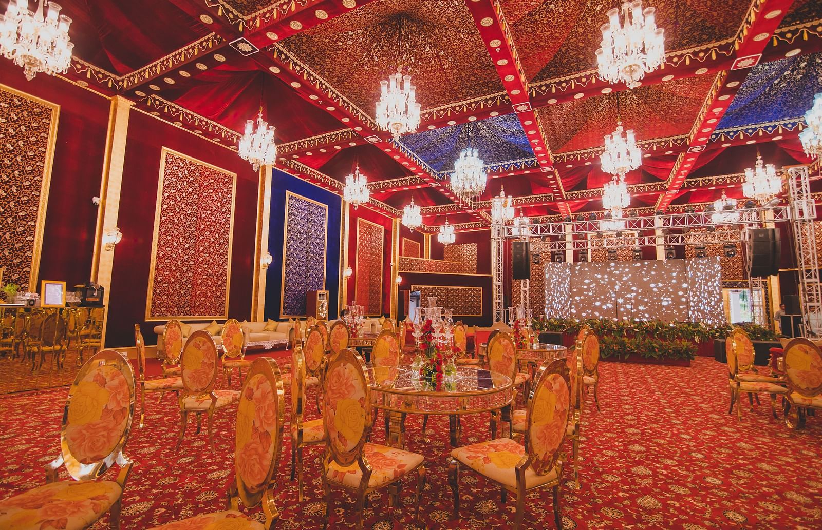 Image of a banquet hall with chairs and chandeliers hanging from the ceiling at Rajasthali Resort & Spa Jaipur.