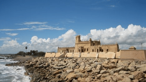 Dansborg Fort by the sea under a sky with scattered sky in Tranquebar