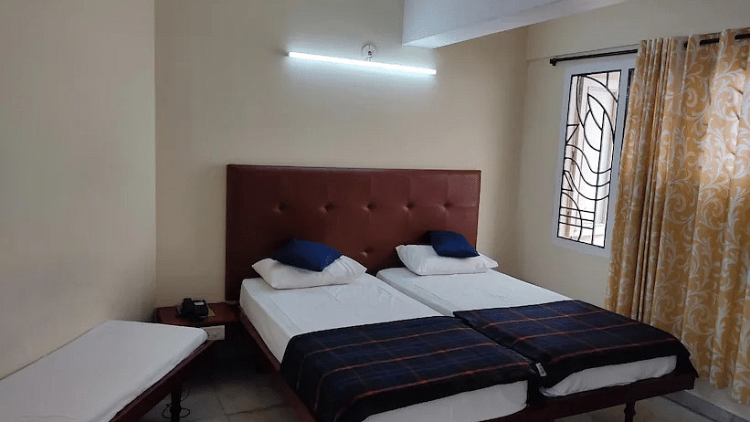 Side angle of room with cosy bed - Hotel Ram International,  Pondicherry