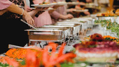 Buffet counter at Uday Palace Convention Centre featuring caterers serving food on the plates
