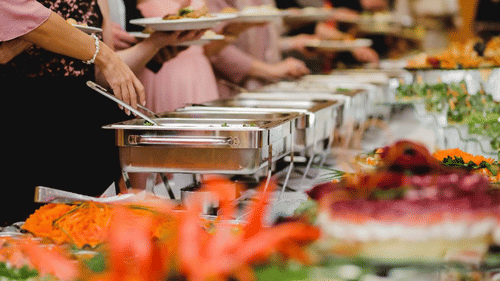 Buffet counter at Uday Palace Convention Centre featuring caterers serving food on the plates