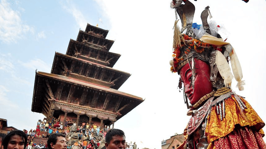 A masked Lakhey dancer performing with the iconic five-story Nyatapola Temple pagoda standing in the background in Bhaktapur, Nepal.