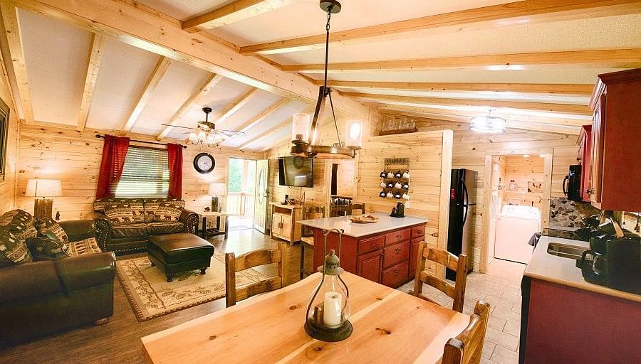 corner view image of the dining area also featuring the kitchen and the common seating area with a wooden ceiling - Historic Tapoco Lodge