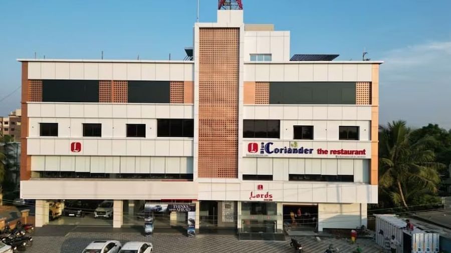 The image shows a multi-story building with signage indicating Coriander the restaurant and Lords at the entrance - Lords Eco Inn Navsari.
