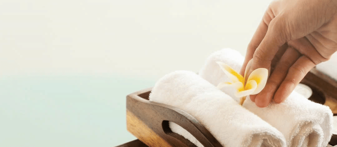 A person keeping flowers on a stack of towels 