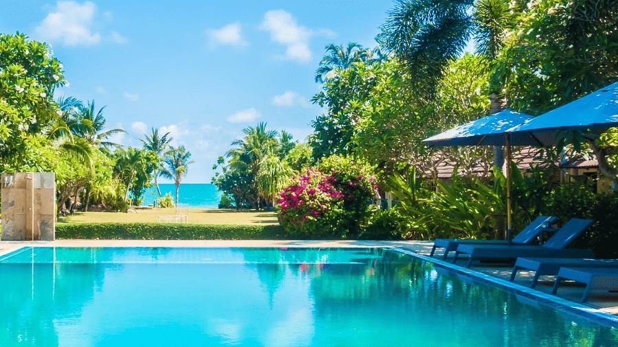 The crystal-clear outdoor swimming pool at Lords Riverside Resort surrounded by tropical greenery.