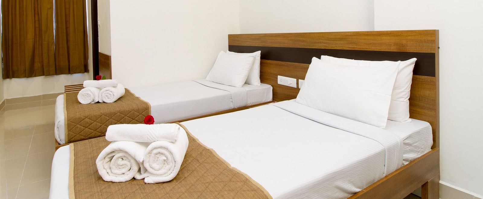 A room at Sanctum Suites Whitefield, Bangalore offering two single beds and a small seating area.