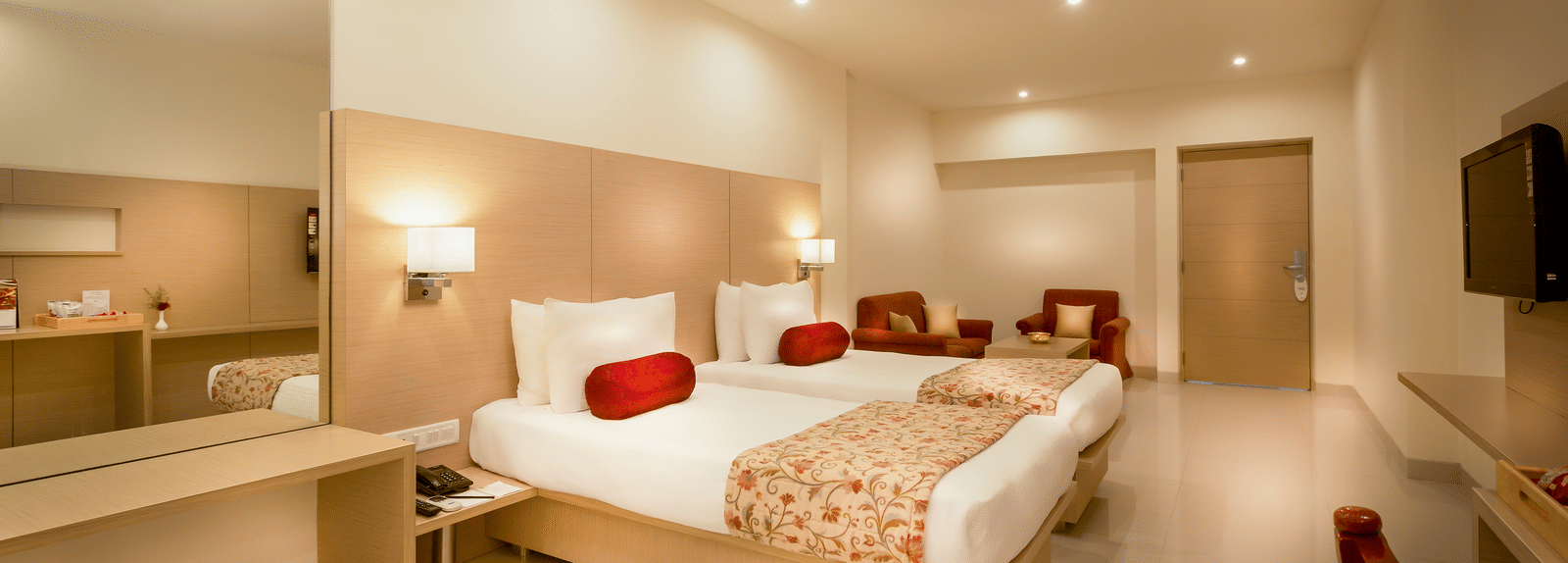 One of the rooms in Tiruttani featuring a king size bed with a work desk and TV at Regency Tiruttani by GRT Hotels