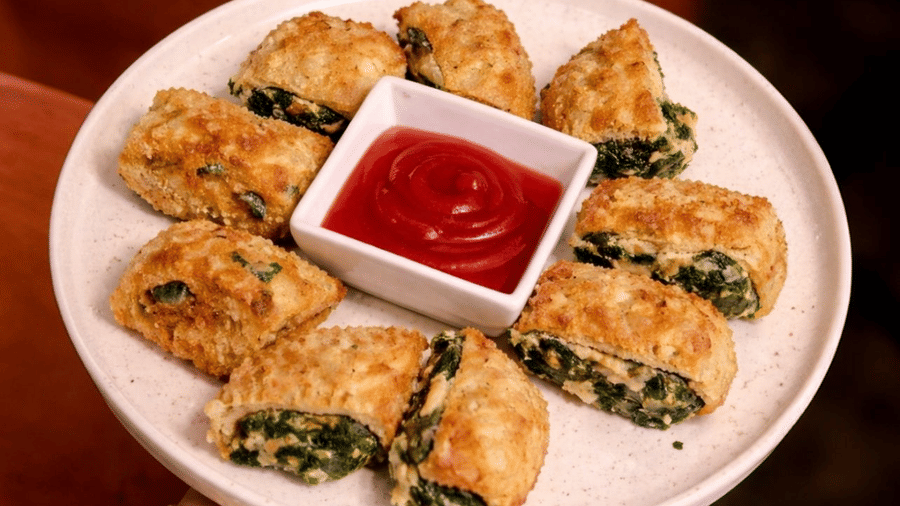 A plate containing sliced rolls and a small bowl of red dipping sauce is displayed at Amantra Shilpi Resort, Udaipur.