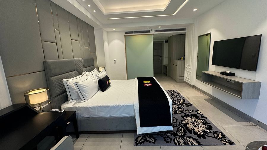 an image of a deluxe room with a television and a wardrobe at Mastiff Select Mandavya Dharamkot, McLeodganj
