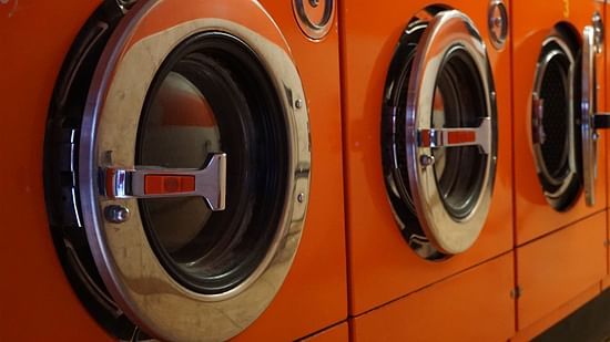 3 red front door washing machines stacked side by side
