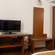Hotel room desk area at Featherlite Evoma Hotel with a wooden TV console, a work desk and wooden flooring throughout the whole space.