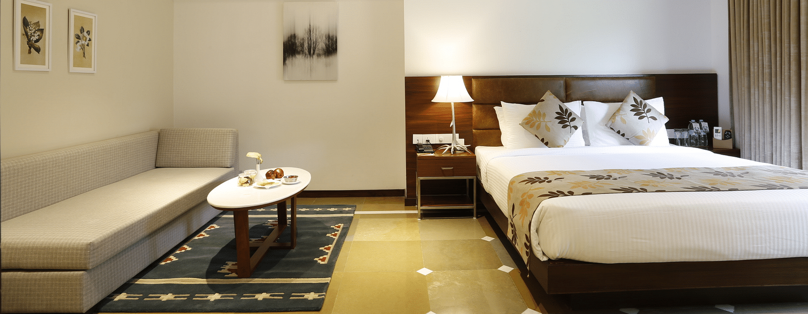 An image of a master suite bedroom with king size bed, a bedside table next to it with a lamp, and a sofa with centre table - The Riverview Retreat, Corbett