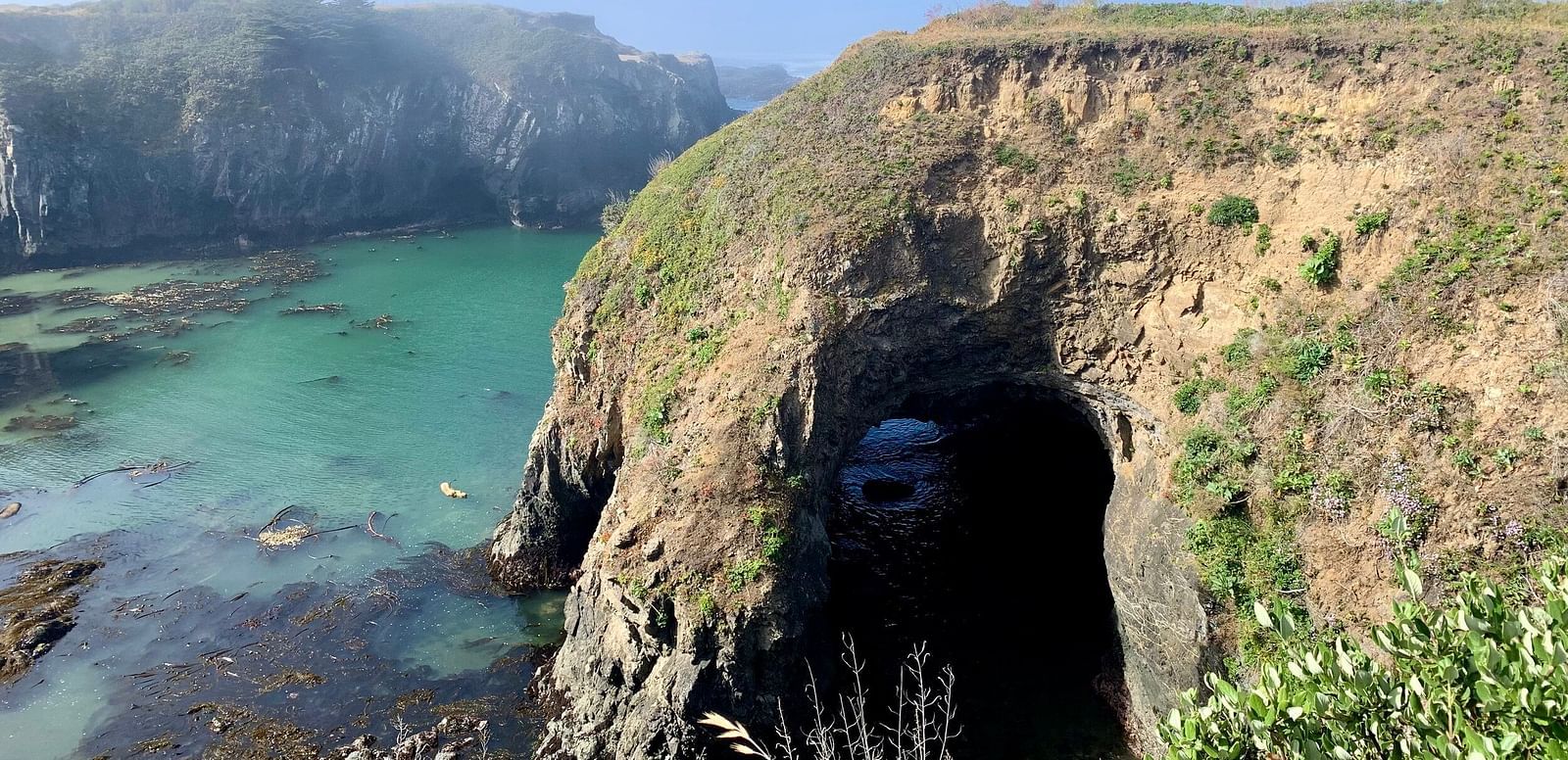 A huge arch in the middle of a mountain that leads to the ocean