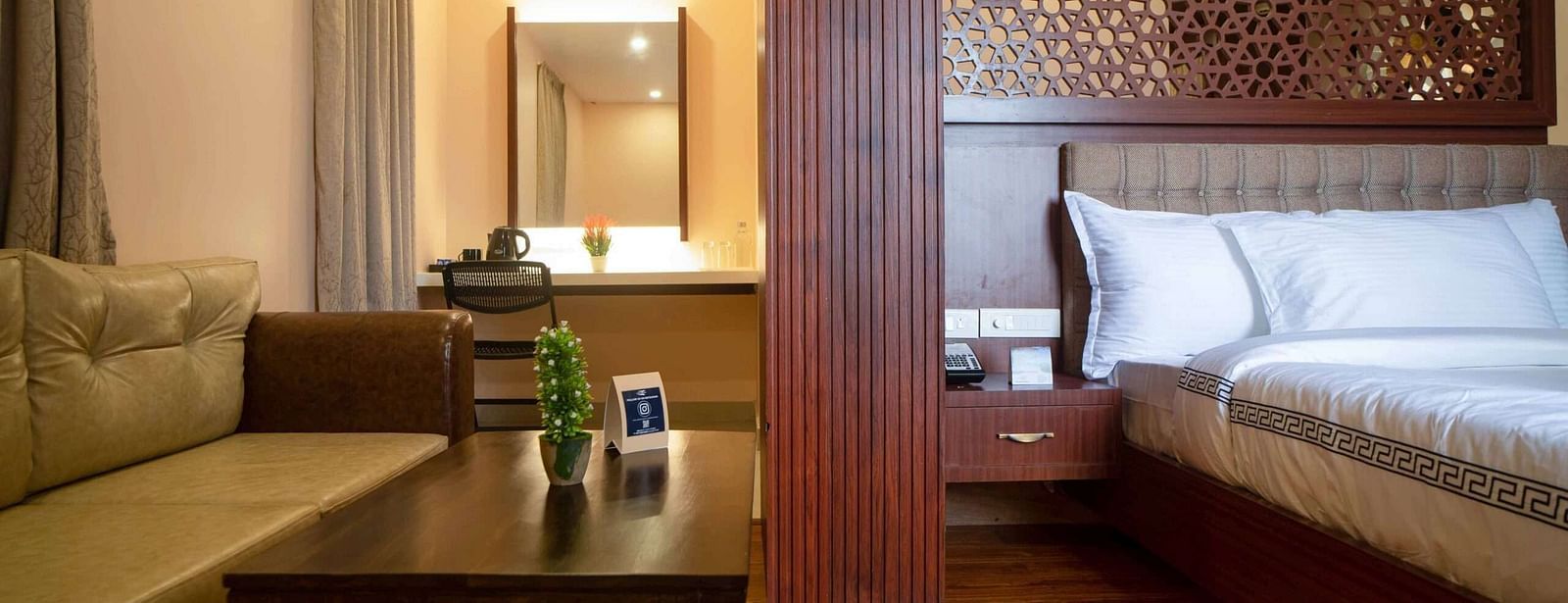 A well-appointed suite at Mansha Palace features a comfortable bed, a seating area with a coffee table, and a mirror.