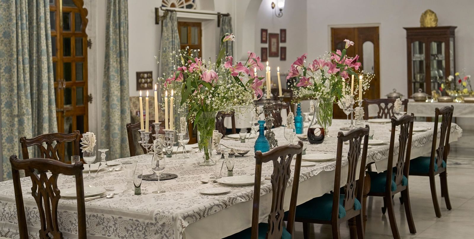 image highlighting the long dining table decorated with flowers and candles at dev shree, deogahr