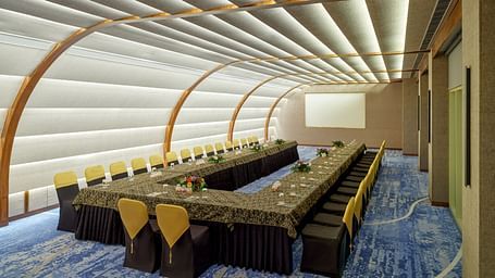 Image of the Panorama Hall at Swosti Premium Beach Resorts in Puri featuring a large U shaped sitting arrangement and a projector in the background
