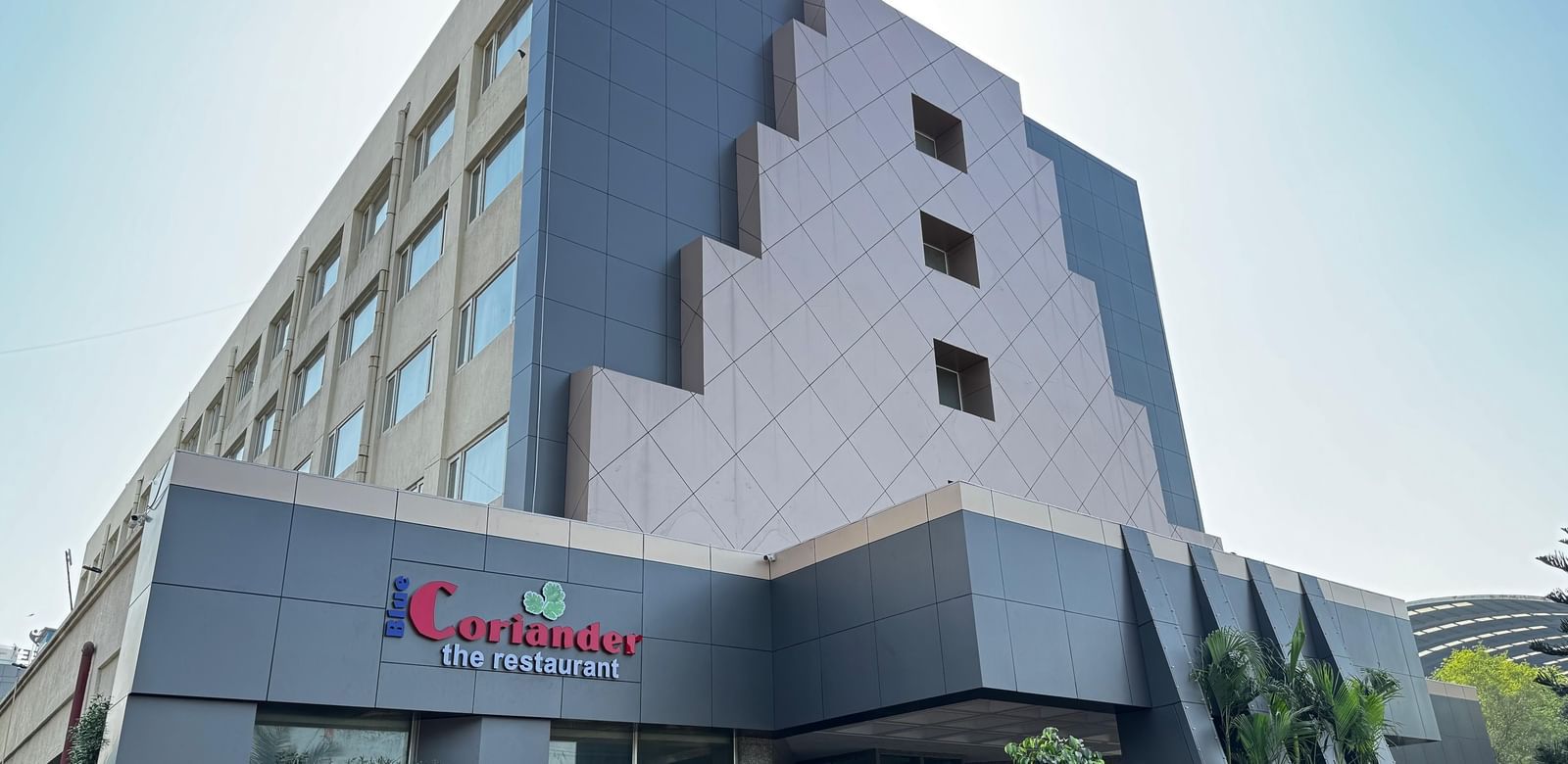 A low-angle shot of a modern, multi-storey building with a red logo.