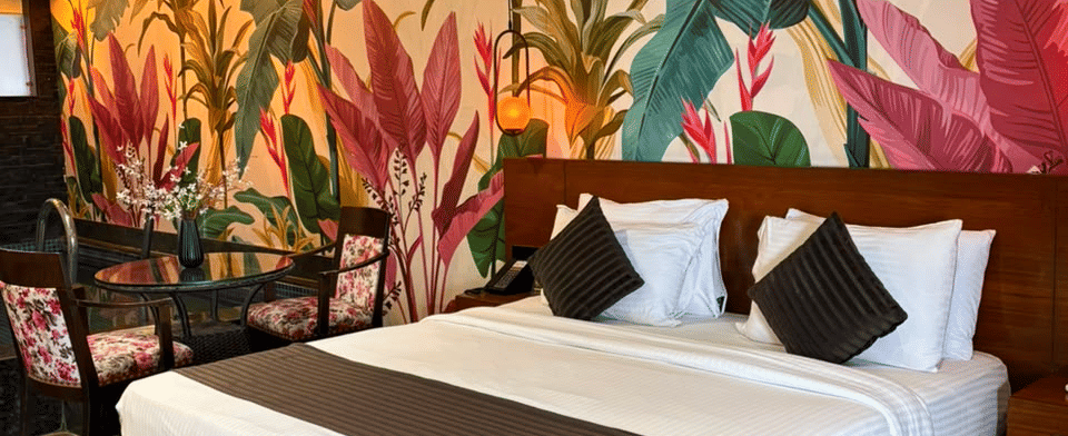 King Room, King bed against the hand-painted banana-leaf mural