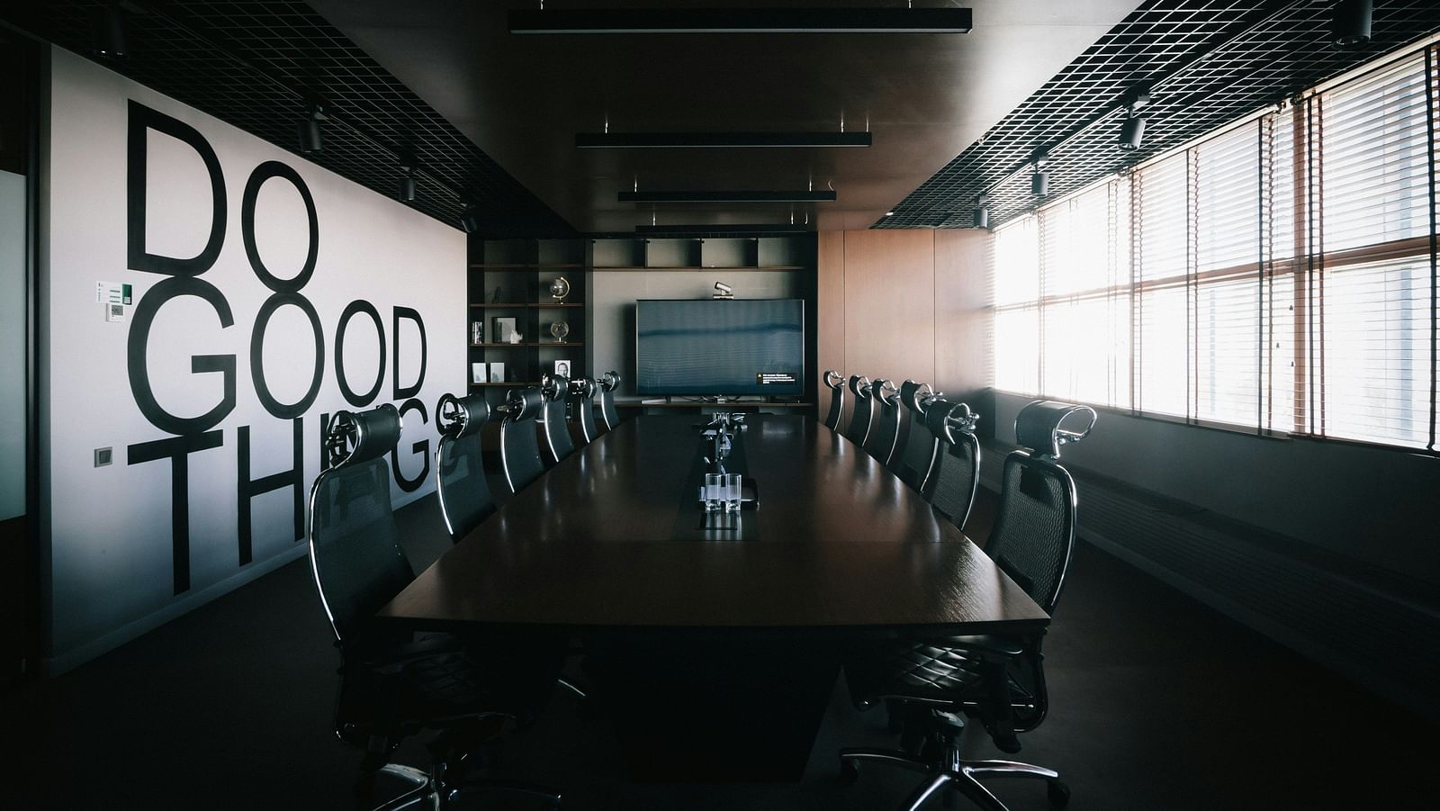 A stylish boardroom with a motivational quote displayed on the wall.