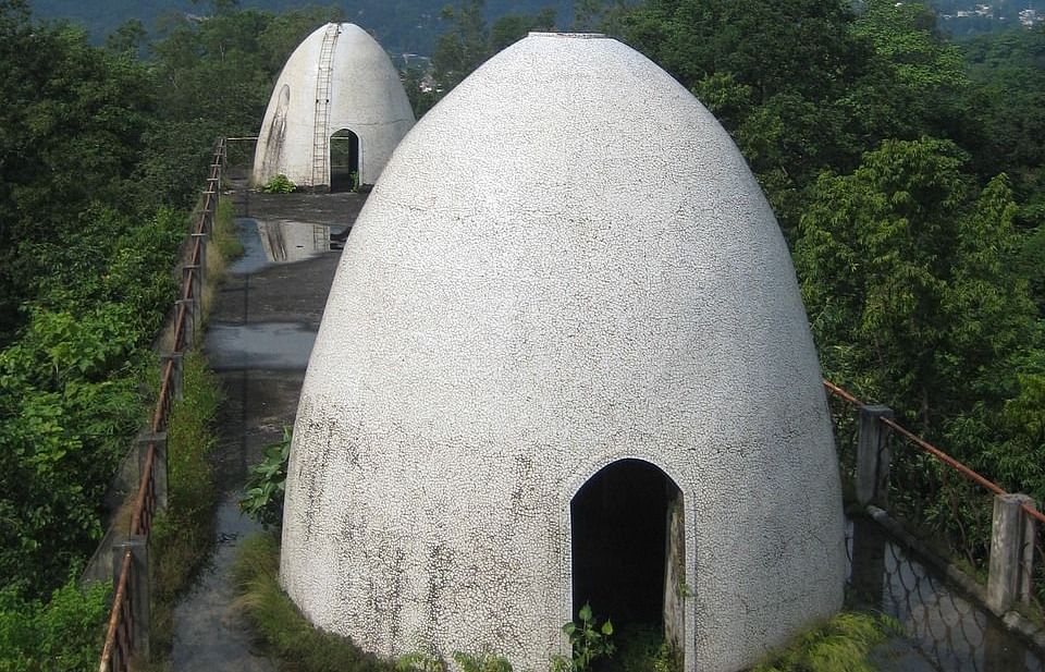 An image of a tomb kind of structure with a entrance and the structure is surrounded by trees around