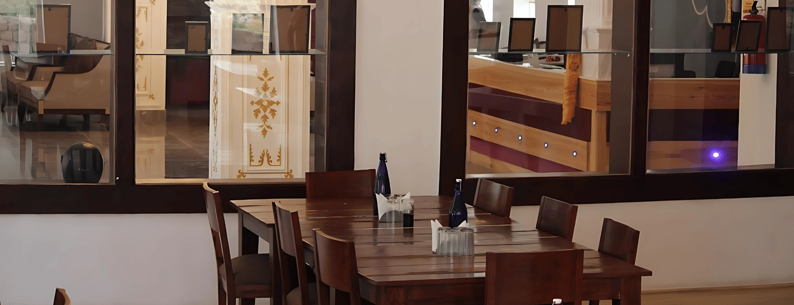 View from the dining area toward the reception desk through large glass partitions at Hotel Dekiling by Eastlynn Collections, Leh.