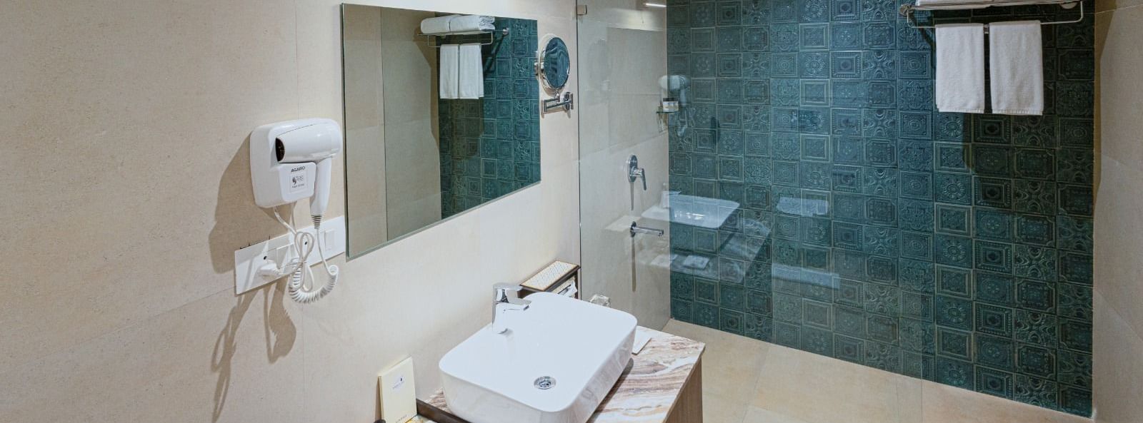 Bathroom at Bamboo Saa Resort & Spa, Udaipur featuring teal patterned tiles in shower area.