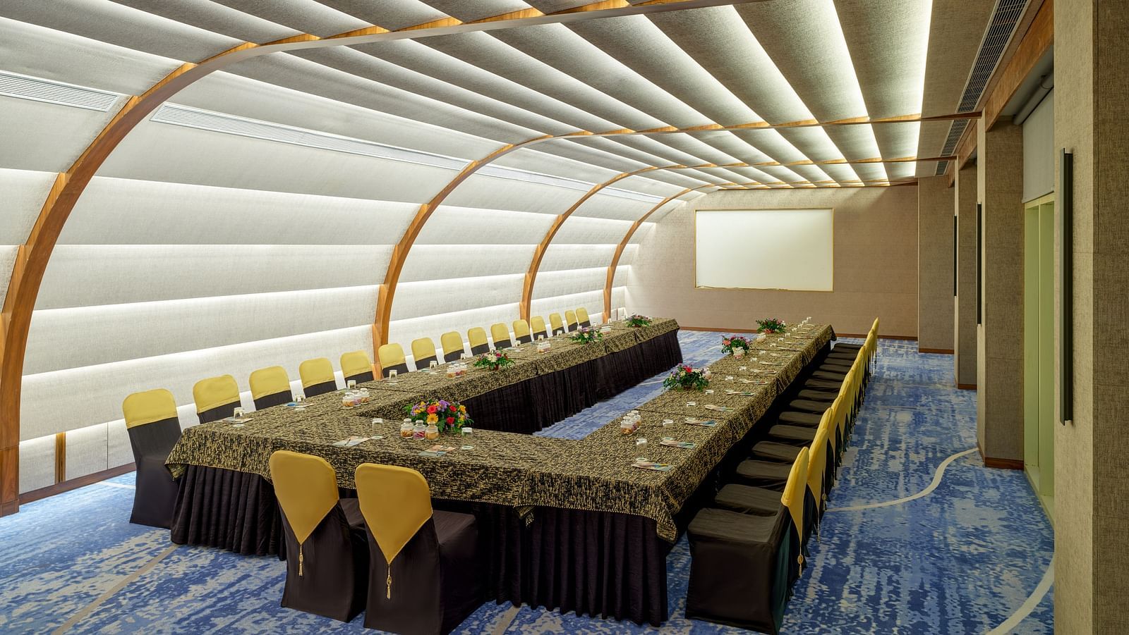 Image of the Panorama Hall at Swosti Premium Beach Resorts in Puri featuring a large U shaped sitting arrangement and a projector in the background