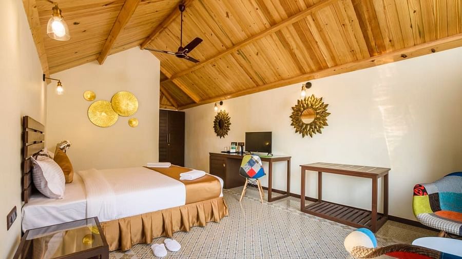 A cozy and comfortable bed beneath a wooden ceiling at Stone Wood Resort, Mandrem