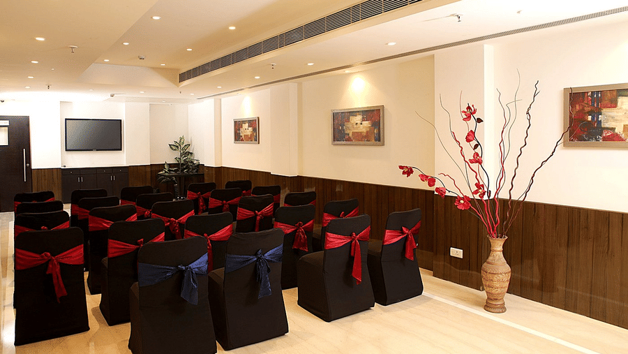 Neat rows of black chairs with red bows face a screen in the meeting room at Eastlynn Collections Huda City Centre.