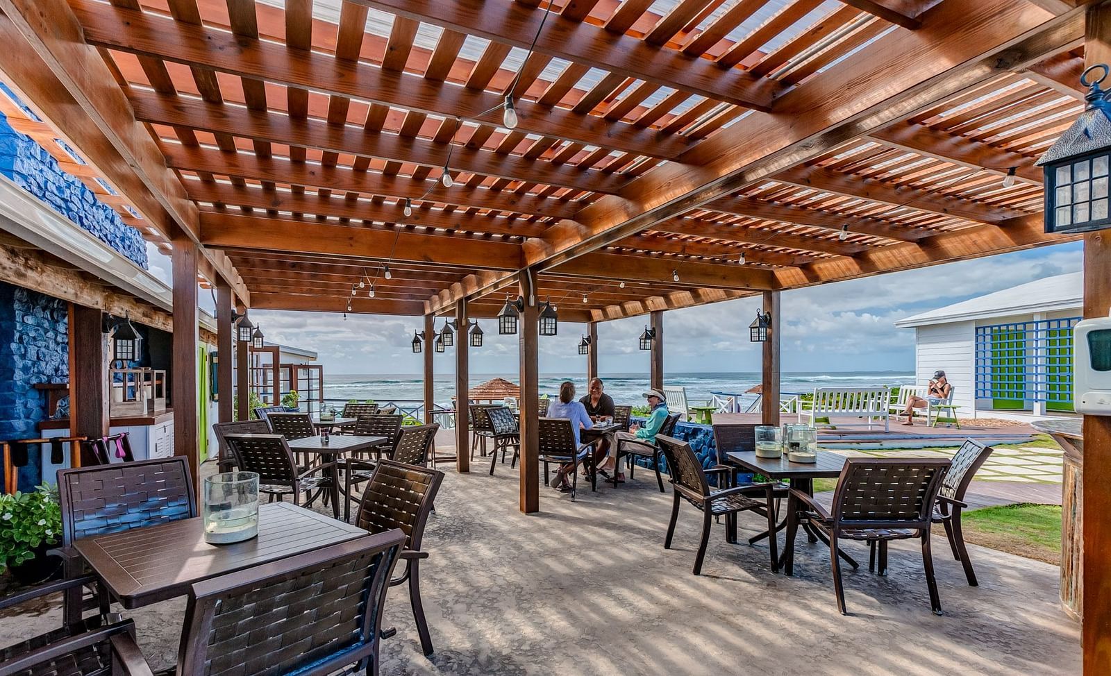 Outdoor dining space with wooden roof and tables | Abaco Inn