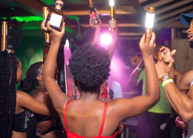 People dancing and celebrating at a lively nightclub with vibrant lights and an energetic party atmosphere, showcasing the nightlife vibe near Hotel 39 in Montego Bay.