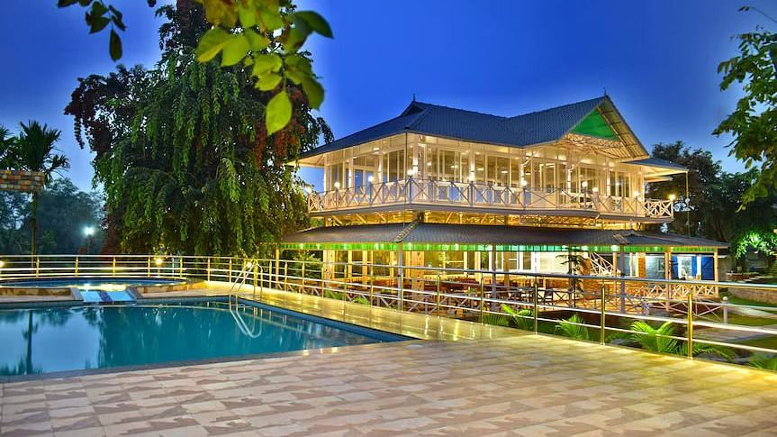 Elegant resort lit up at night with a poolside seating area and vibrant ambiance.
