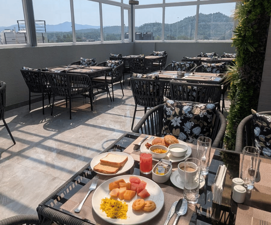 A breakfast spread on the rooftop terrace overlooking the hills at Signum Tathastu Boutique Hotel, Haridwar