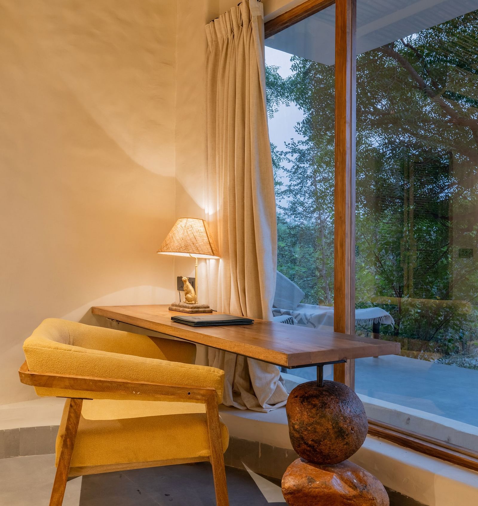 Close-up of a seating with a wooden bench, throw pillows, and decorative vase.