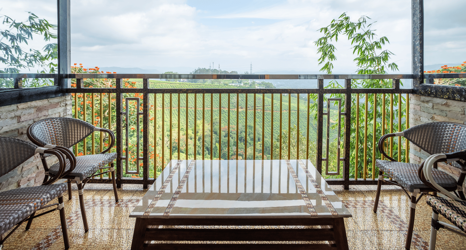 The private balcony in Family Jacuzzi Room in the Outdoor Seating Area at Parakkat Nature Hotel and Resorts, Munnar, featuring a metal railing, seating area, and a wide view of greenery.