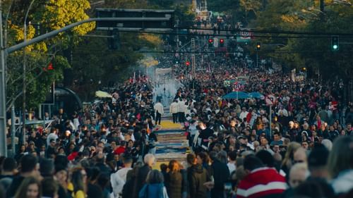 Aerial view of a crowded outdoor event with people gathered along a road near Heritage Village Resorts & Spa, Goa.