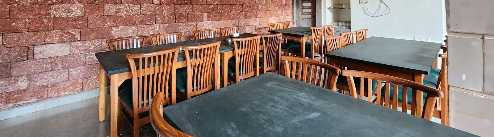 There are tables and chairs around them with warm lighting and a wall-mounted TV at SeaFort Beach Resort