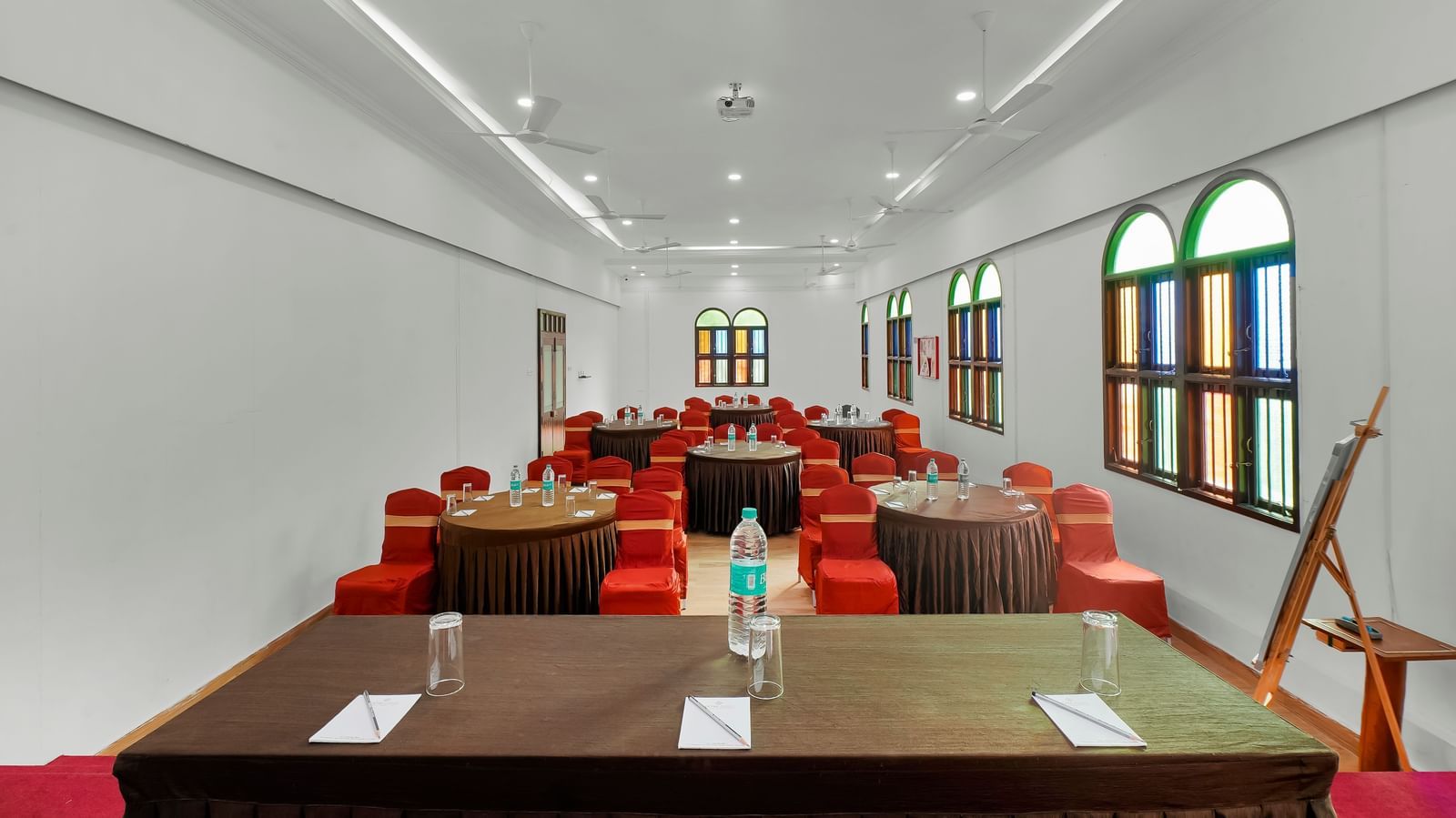 View from the front of the banquet hall with chairs arranged around the round table at WOW Bungalow, Yercaud.