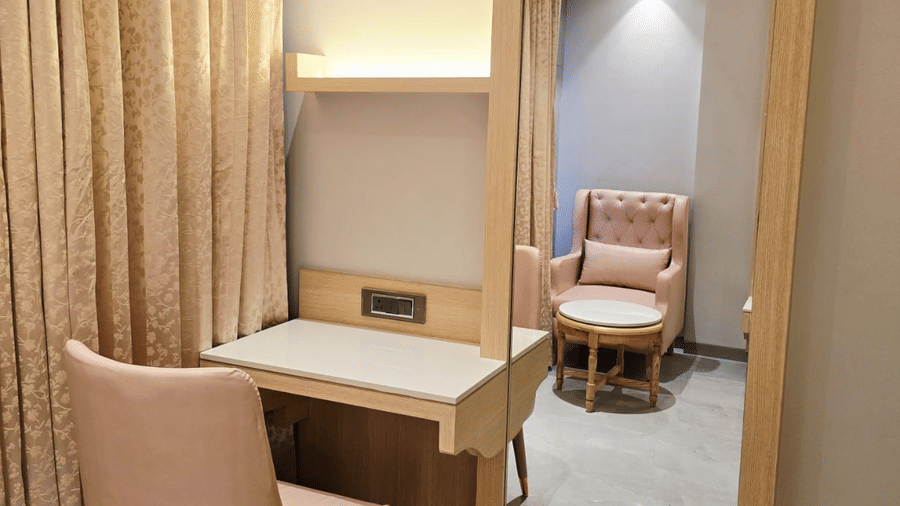 Compact workspace with desk, chair, and mirror near window at Hotel Mumbai House, Digha, Airoli.