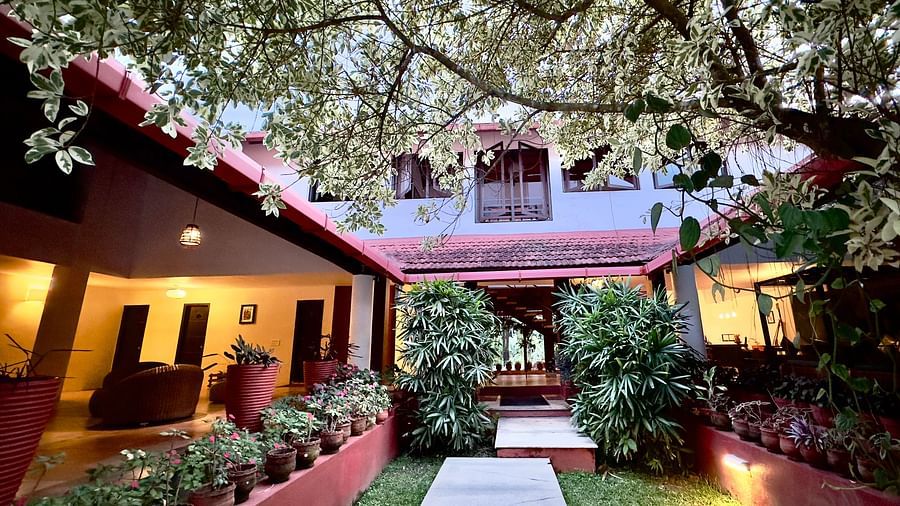 an open area in the interior of the hotel with bushes and flower pots - Kadkani River Resort, Coorg