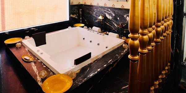 Image of a washroom with a jacuzzi and a chandelier above it at Rajasthali Resort & Spa Jaipur.