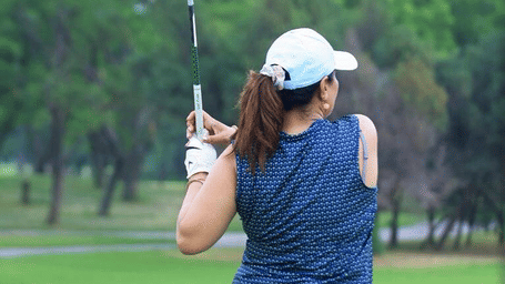 A woman swinging the golf bat at Karma Chalets.